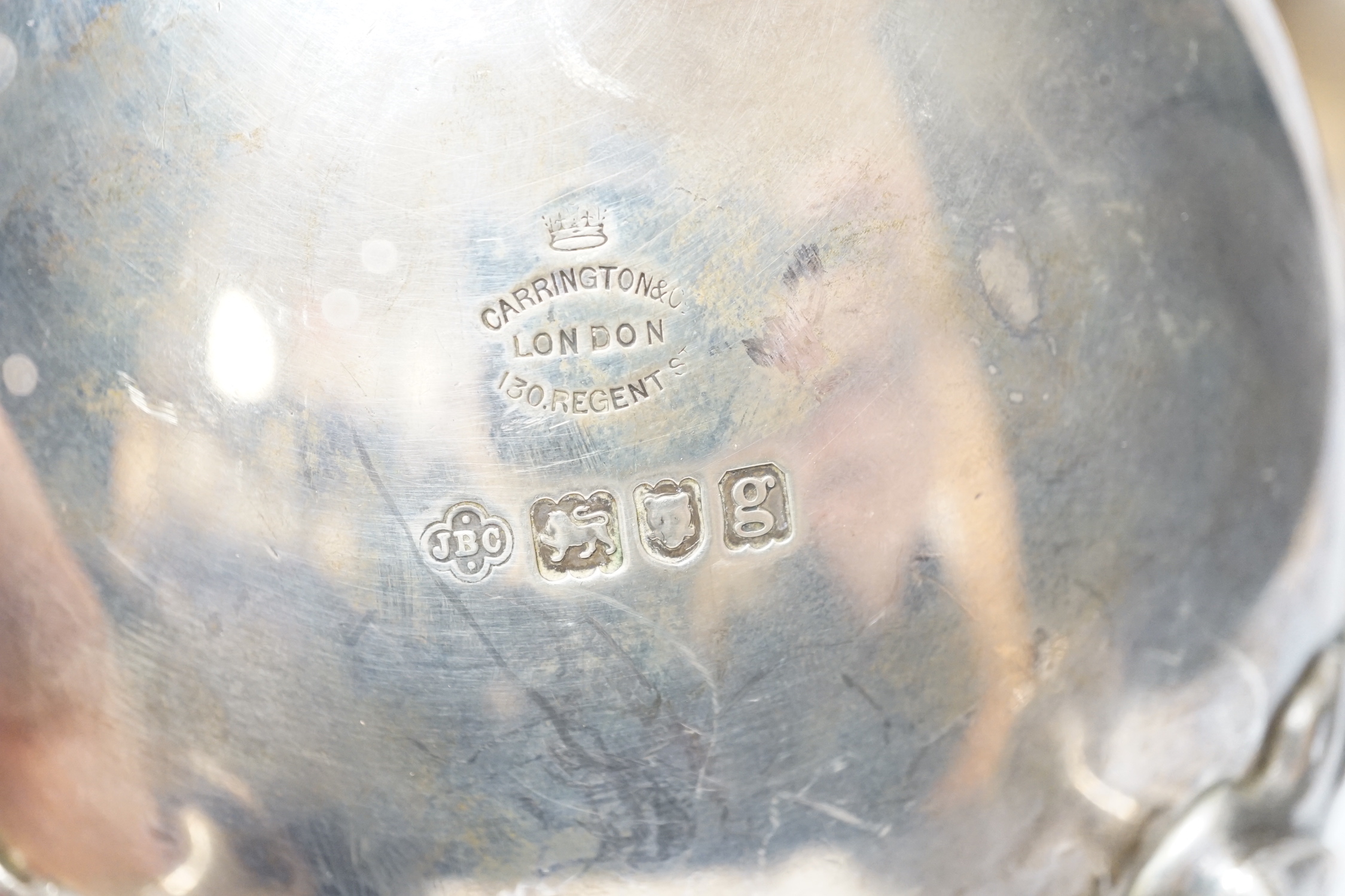 A pair of Edwardian silver sauce boats with shell knees, on three fluted feet, Carrington & Co, London, 1902, length 20.8cm, 33.9oz.